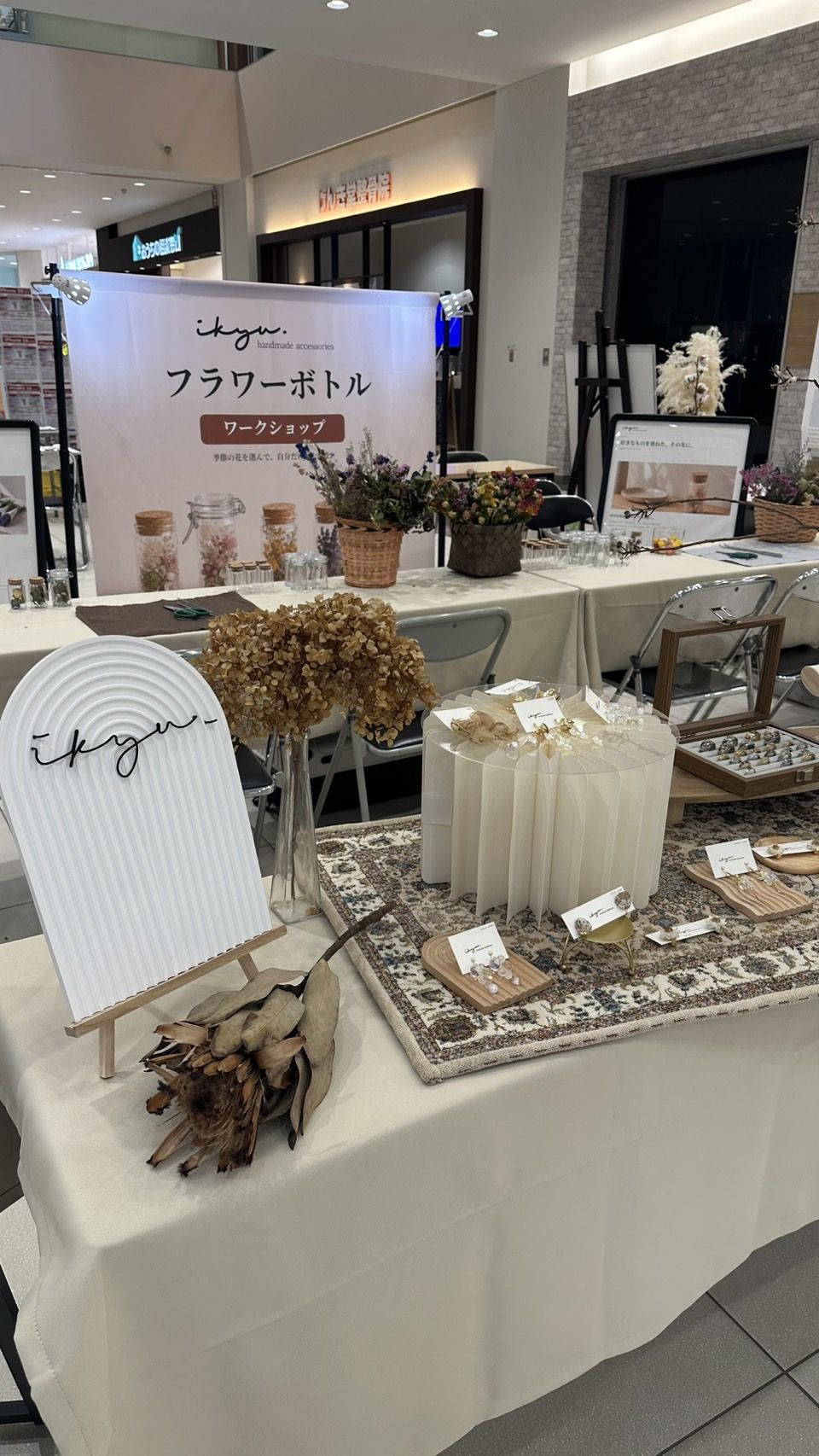 ikyuのロゴサインとハンドメイドアクセサリーが並ぶ展示テーブル