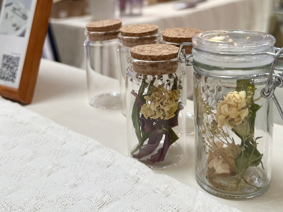 コルク栓の小瓶に季節の花が詰められた、完成したフラワーボトル。