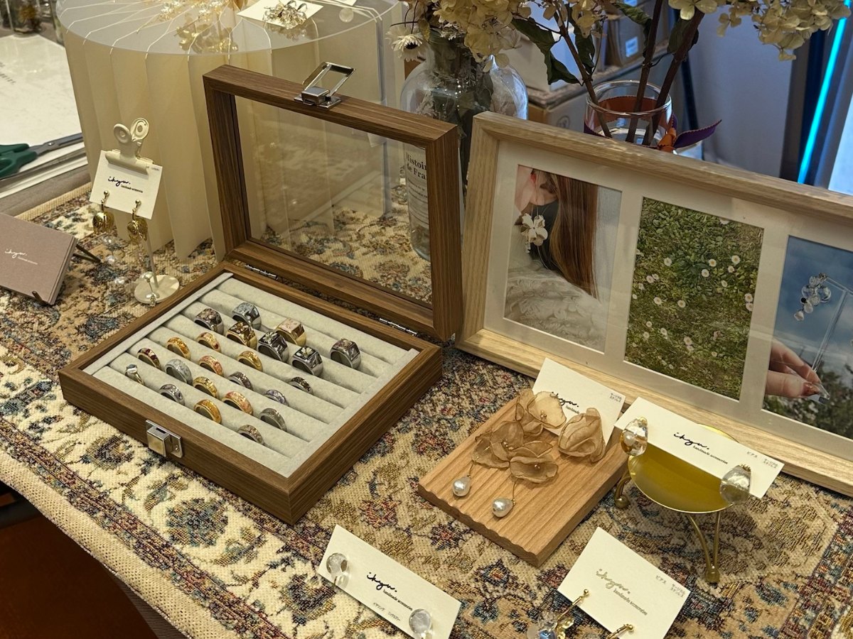 ikyuのアクセサリーの展示。リングの並ぶケースやイヤリング、ドライフラワー、ワークショップのポスター