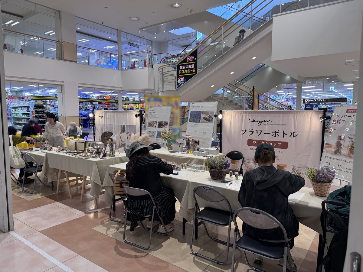 ザ・ビッグ厚別店のイベントスペース全体。左にikyuのアクセサリー展示、中央の制作テーブルで参加者がフラワーボトルを制作している