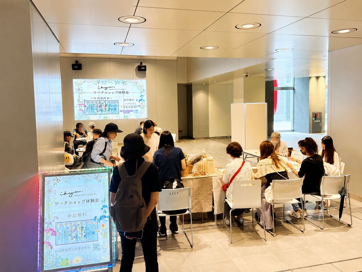 チカホ北三条広場のワークショップ体験会。テーブルを囲んで手を動かす参加者と、順番を待つ人たち